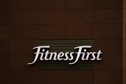 Close-up of FitnessFirst gym sign on a contemporary brown wall.